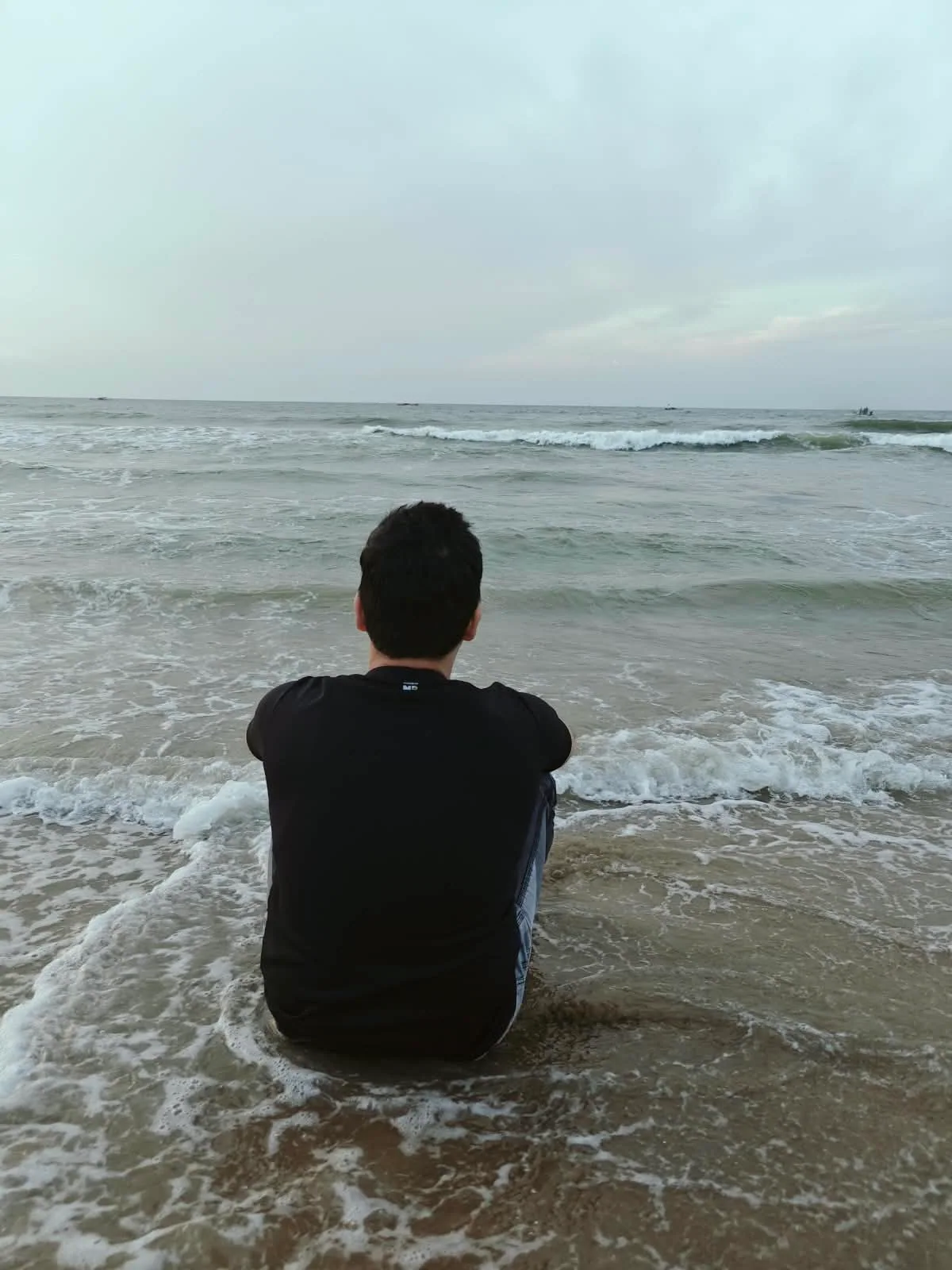 Gaurav sitting at the shoreline and looking out across the sea